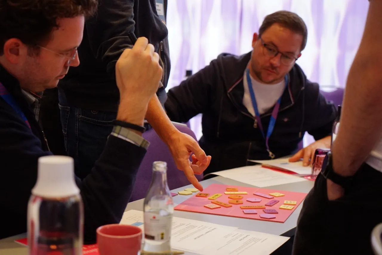 Workshop-Facilitator erklärt Architektur-Konzepte während Team-Diskussion